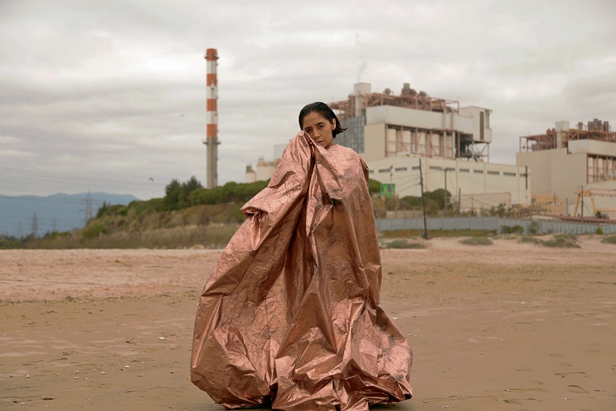 Ventanas-Quinteros. Mujer parada con manta de cobre frente a planta de quintero. Fotografia de Jose Antonio Luer