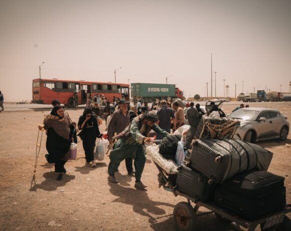Una familia afgana, que incluye a una mujer con discapacidad y niños pequeños, cruza la frontera desde Irán rumbo al centro de recepción de la OIM en Islam Qala. Foto: OIM 2025/Mohammad Osman Azizi